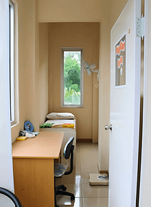 Infirmary room showing a bed and table with window on the back in Sekolah Karya Anak Bangsa.