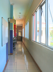 School hallway leading to classes with windows on the side for a natural lighting in Sekolah Karya Anak Bangsa.