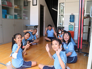 Primary children sitting in a circle smiling and laughing.