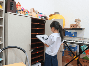 A young student placing laptop on the drawer inside the Sekolah Karya Anak Bangsa computer room.