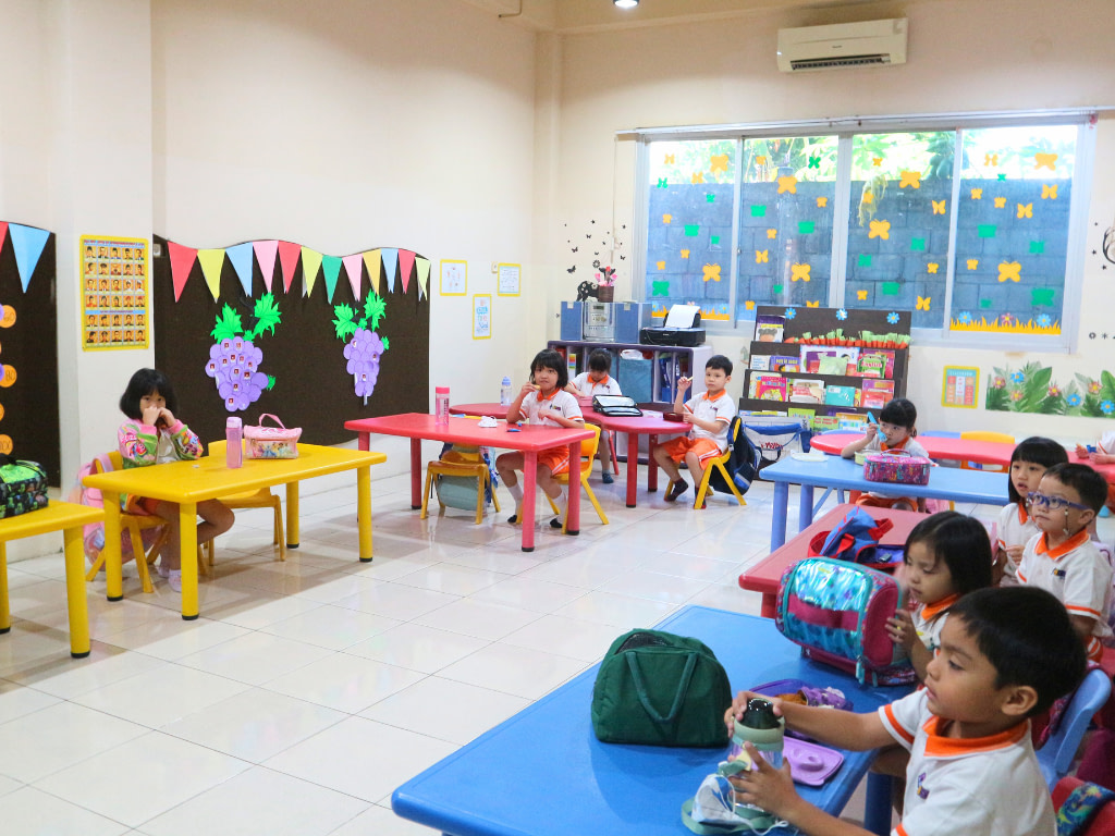 Kindergarten (TK) class in Kiddy School Manado, where young students are sitting on their table wearing uniform.