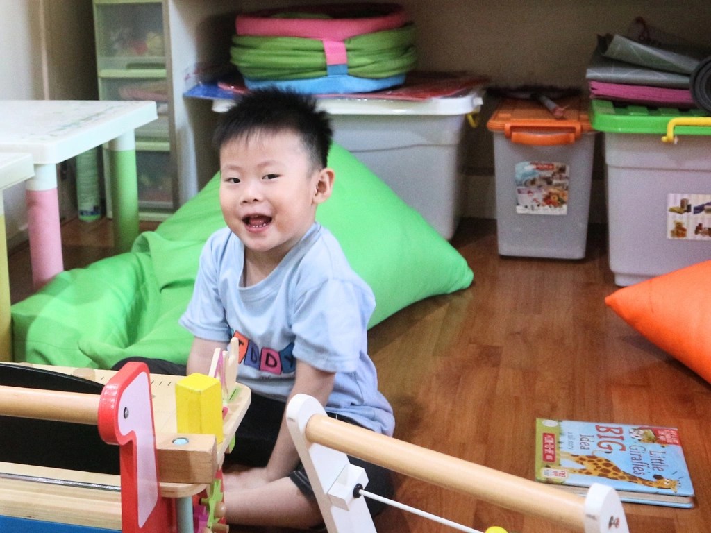 playgroup.6 Young Kiddy School Manado playgroup student smiling and playing with toys.