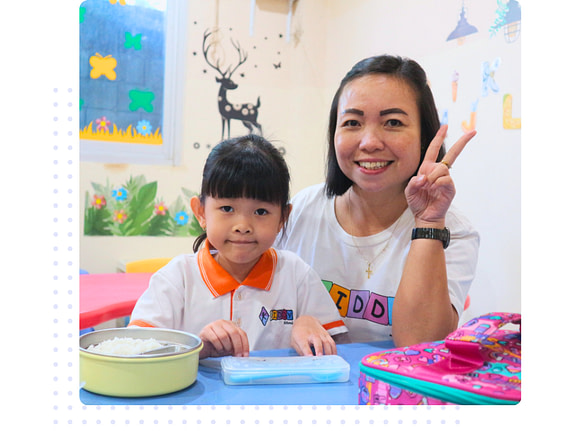 tk.1 A teacher and a young kindergarten student sitting and smiling